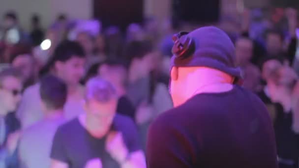 Mann spielt Musik, DJ tritt in Nachtclub auf, Leute tanzen — Stockvideo
