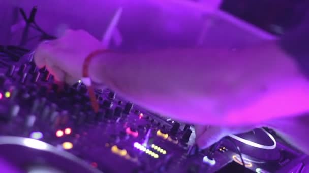 Mãos masculinas DJ tocando trilhas sonoras, pressionando botões na plataforma giratória — Vídeo de Stock