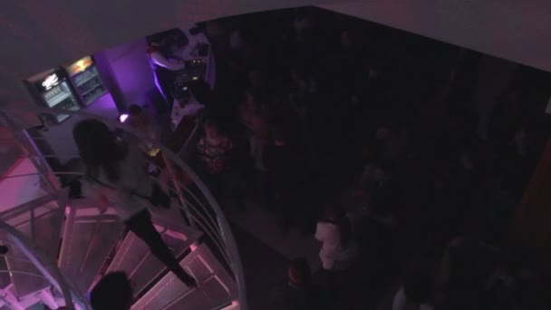 Muchos hombres, mujeres subiendo y bajando escaleras en espiral en el club nocturno — Vídeos de Stock