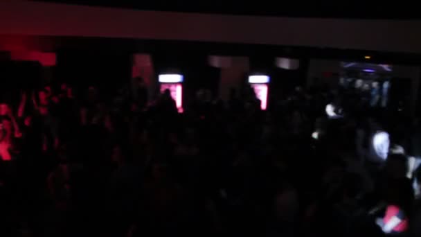Люди активно танцуют, аплодируют диджею, играющему в клубе — стоковое видео