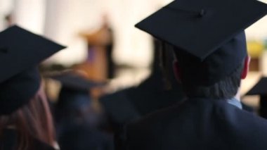 Heyecanlı öğrenciler kapaklar ve üniversite mezuniyet töreninde applauding önlük