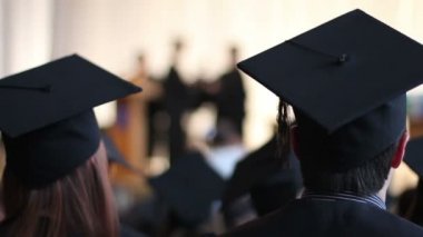 Öğrenciler sahnede mezunu'nın el sallayarak dean dikkat et. Neşeli alkış