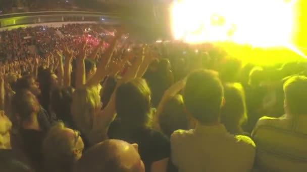 Guys waving hands simultaneously at concert. Amazing light effects on stage — Stock Video