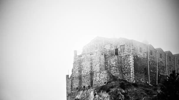 Černá a bílá tajemné strašidelný hrad stojící na mlhavé vrchol hory