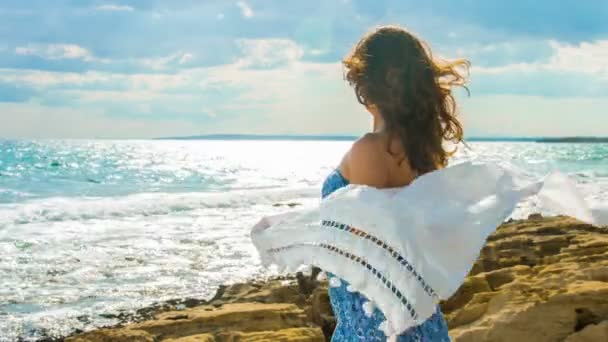 Mooie brunette in een romantische stemming reputatie op strand, genieten van winderig weer — Stockvideo