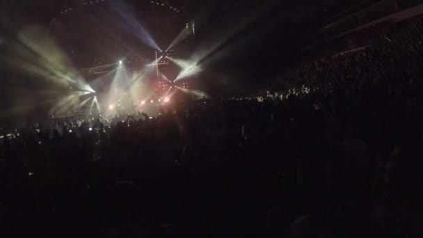 Minsk, Belarus - April 15, 2015. Robbie Williams concert at Minsk Arena. Dark silhouettes of people dancing, jumping, applauding to popular musician — Stock Video