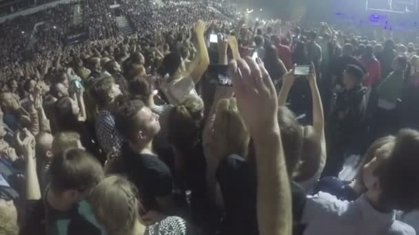 Minsk, Belarus - April 15, 2015. Robbie Williams concert at Minsk Arena. Crowd of young guys filming performance on smartphones. Security guard at work — Stok video