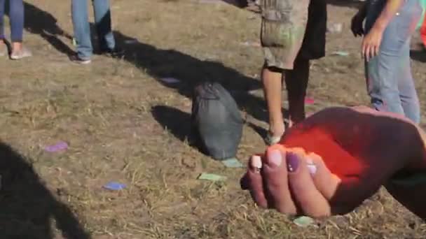 Fille verser de la peinture en poudre orange à la main, s'amuser avec des amis, Holi fest — Video