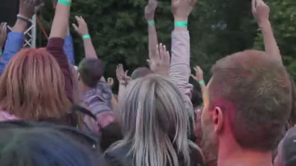 Young men and women enjoying traditional paint fest, jumping with hands in air — Stock Video