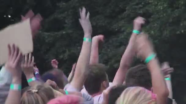 Mnoho rukou mával do vzduchu, šťastné mladé lidi, skákání, párty na festivalu — Stock video