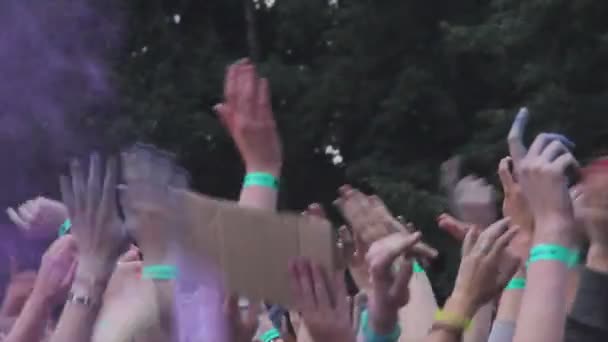 Hands of many people throwing colorful powder in air at traditional paint fest — Stock Video
