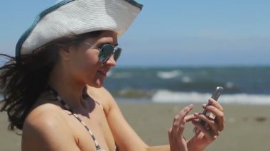 Güzel kadın gülümseyen, numara çeviren, telefonda konuşan, sahilde arama biten