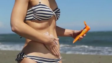 Güneş yanıklarından cildi korumak için güneş kremi uygulayan güzel vücut ile Sıcak kadın