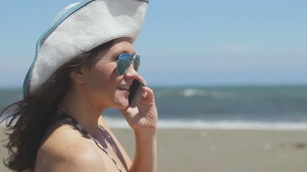 Ung kvinna talar i telefon på stranden, stormigt väder, havsvågor, panoramautsikt — Stockvideo