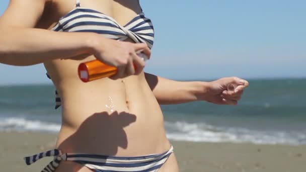 Mujer delgada con cuerpo caliente aplicando aceite protector solar, frotando el vientre y las caderas suavemente — Vídeos de Stock