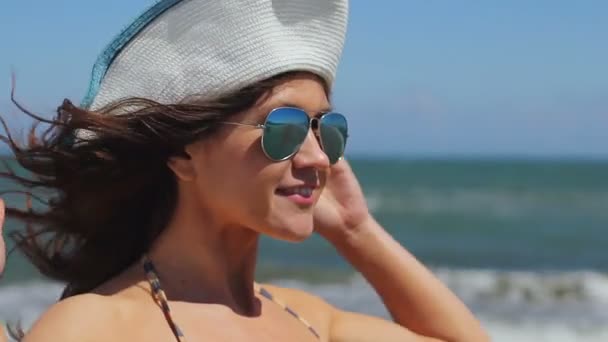 Modelo femenino profesional posando para sesión de fotos en la playa del mar, sonriendo a la cámara — Vídeo de stock