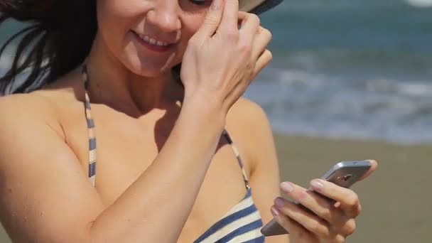 Девушка делится селфи в социальных сетях, наслаждаясь своим пребыванием на летнем пляже — стоковое видео