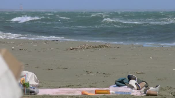 Chaussures de touristes, vêtements abandonnés sur la plage, temps froid et orageux, ouragan — Video