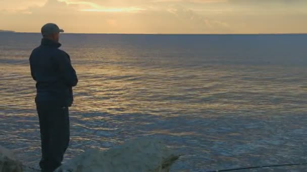 Pescador arrojando piedras al agua al amanecer, al atardecer. Hora mágica, relajación — Vídeos de Stock