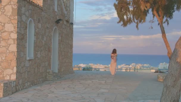 Giovane donna sola guardando il cielo serale sopra il mare. Vacanze in località balneare — Video Stock