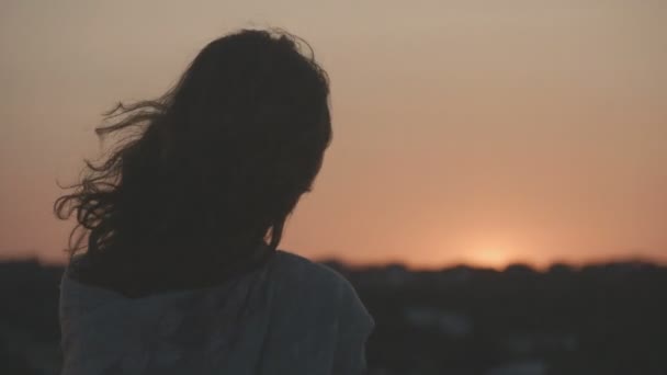 Silueta de una joven hembra solitaria mirando atardecer, amanecer. Hermoso cielo rosa — Vídeo de stock