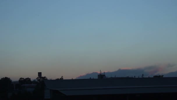 Zeitraffer eines am Horizont wütenden Flächenfeuers, Dämmerung im Dorf, Einspielung — Stockvideo