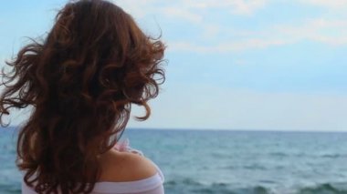 Güzel genç kadın ağlıyor, gözyaşlarını silerek, deniz kenarında, seyir görüntülemek arkadan
