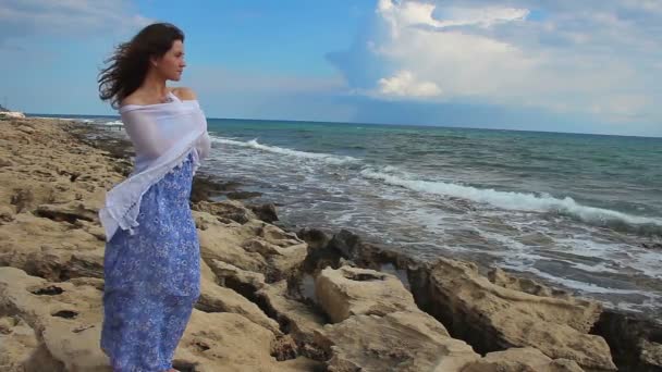 Jolie jeune femme d'humeur romantique debout près de la mer, regardant les vagues orageuses — Video