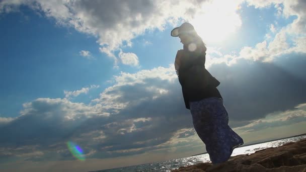Silueta osamělá žena stojí na pobřeží ve slunečním světle, rozbitý vztah
