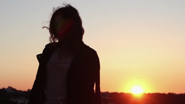 Belle femme dansant au coucher du soleil, silhouette de femme ivre passant à la musique — Video