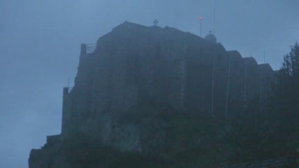 Проміжок часу туману, що покриває стару кам'яну церкву на горі, таємнича атмосфера — стокове відео