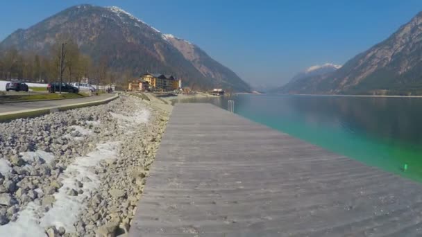 Luchtfoto van houten Lake Quay, diep blauw wateroppervlak, prachtige bergen — Stockvideo