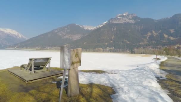 Stone bench at national park in Austrian Alps, snow melting, sunny spring day — Stock Video