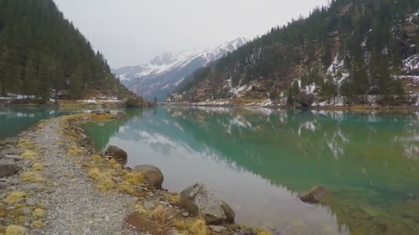 Stony vid sjön, skogen och bergen reflektion i vatten, elektrisk kraftledningar — Stockvideo