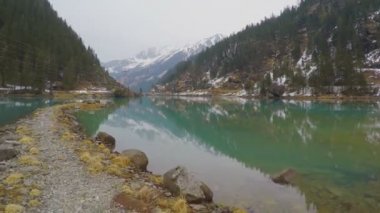 Su, elektrik güç hatları taşlı lakeside, orman ve dağlar yansıması