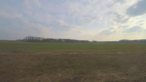 Поїзд, що проходить повз величезні сільськогосподарські поля, заводи, промислова зона, вид через вікно — стокове відео