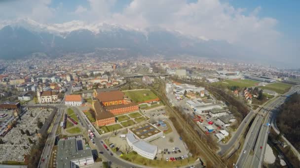 Вид зверху на сучасні дороги, транспортна інфраструктура в місті біля скелястих гір — стокове відео
