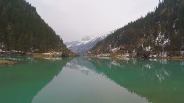 Spiegelglatte Wasseroberfläche, Spiegelung von Himmel und Bergen, immergrüner Wald — Stockvideo