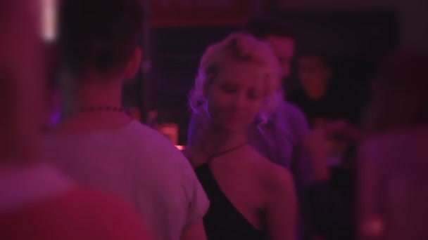 Party im Nachtclub. Jungs haben gute Laune, junge Frau tanzt, genießt Clubmusik — Stockvideo