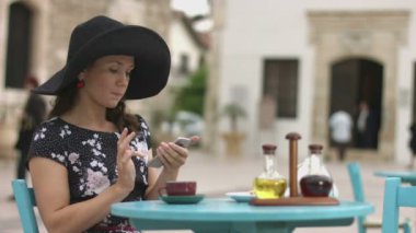 Mutlu genç kadın arkadaşına kafede dokunmatik ekran, telefon numarasını çevirme