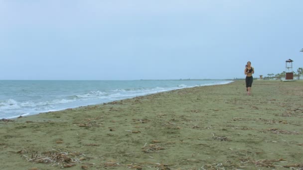 Молодая женщина с здоровым телом бегает по песчаному пляжу утром. Здравоохранение — стоковое видео
