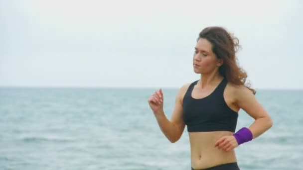 Hermosa joven atleta corriendo al aire libre, entrenamiento para la competencia deportiva — Vídeo de stock