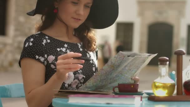 Szczęśliwa młoda kobieta szuka ciekawych miejsc aby zobaczyć, pisanie notatek na mapie miasta — Wideo stockowe