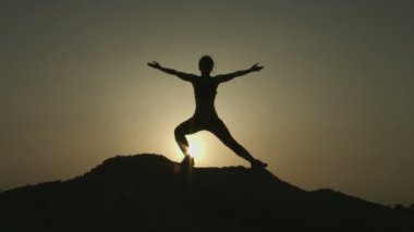 Doğa ile uyum yoga uygulamak ise genç kadının silüeti