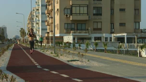 Attraktive junge Frau beim Morgenlauf, die sich um ihren Körper und ihre Gesundheit kümmert — Stockvideo