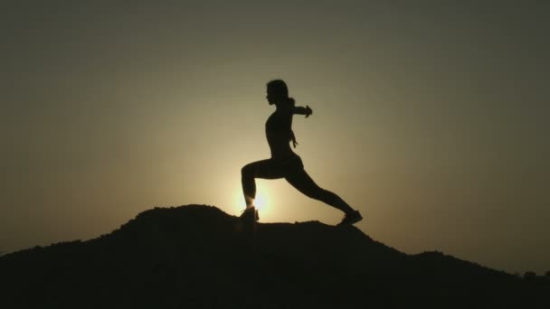 Mujer con cuerpo flexible practicando posiciones de yoga, haciendo ejercicios en las montañas — Vídeos de Stock