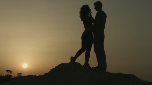 Romantische verhaal van twee personen in de liefde. Silhouet van het paar kussen bij zonsondergang — Stockvideo