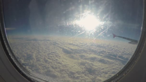 Ein Passagier blickt durch Bullaugenglas auf die Wolkenlandschaft. Anreise per Flugzeug — Stockvideo