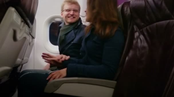 Happy young people laughing, having fun during flight. Man and woman flirting — Stock Video