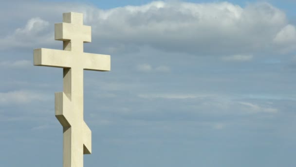 Перехрестя сірих хмар, що летять над кам'яним хрестом на могилі на цвинтарі — стокове відео